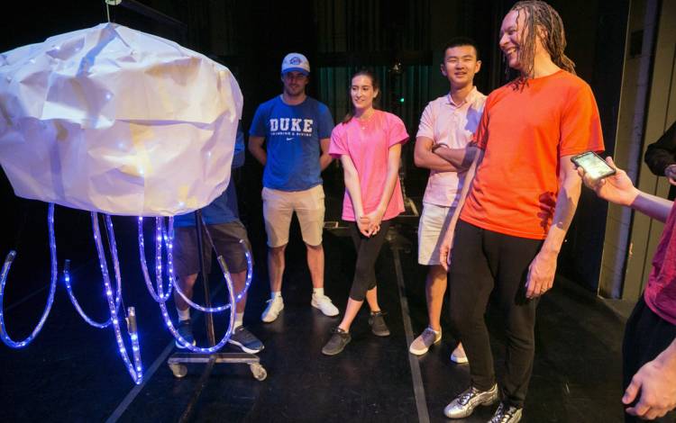 Thomas DeFrantz, in the orange, works with students in the Performance and Technology Composition Workshop.