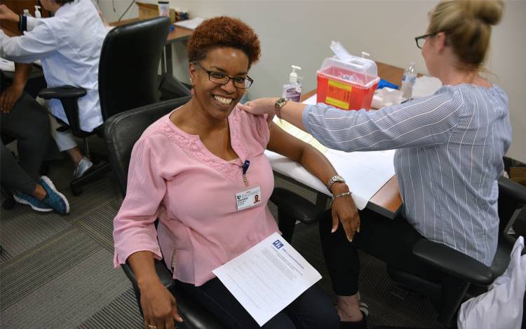 Sharon Slater receives her flu vaccine at the Duke Patient Revenue Management Organization office. Photo by Jonathan Black.