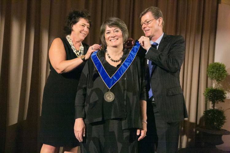 Alumni director Sterly Wilder and President Vince Price award former nursing dean Catherine Gilliss the University Medal.