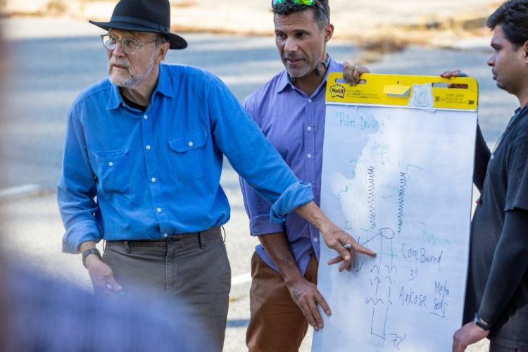 Professor emeritus Peter Malin shows students a drawing of the drilling core