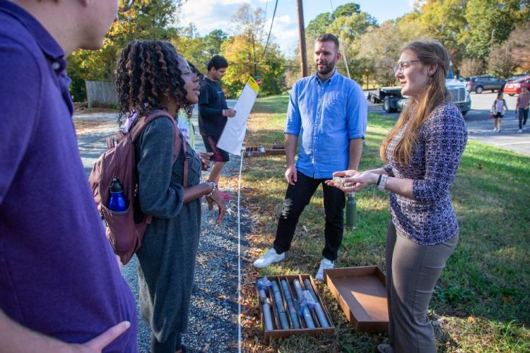 Students and teachers stand with box of core samples