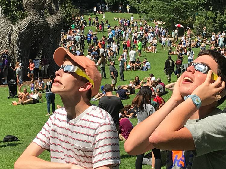 Zack Hersh, 16, of Chapel Hill and Oliver Egger, 16, of Durham watch the eclipse through their glasses.  Photo by Keith Lawrence.