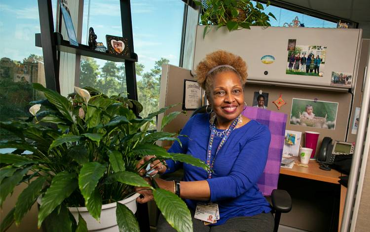 Duke Health Technology Solutions IT Analyst Regina Leak lavishes care on happy plants in her workspace. Photo by Chris Hildreth.