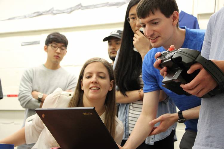 The Duke team communicates with their robot during a test run on campus. Photo by Michaela Kane