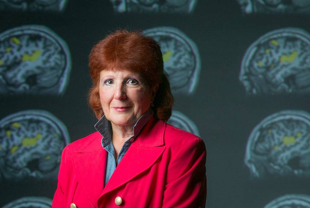 Edna Andrews, photographed in front of images of brain scans. Photo by Megan Mendenhall/Duke Photography