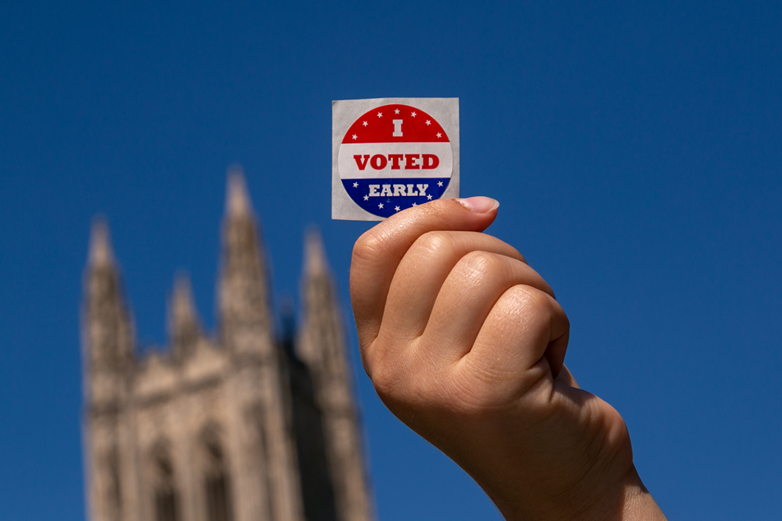 Duke student shows I Voted sticker on Duke's campus