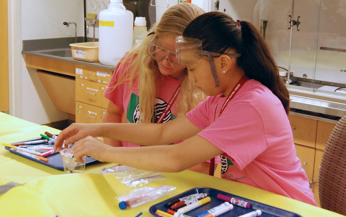 Elizabeth Owens, left, and a fellow camper take part in an experiment at ACTION Science Camp for Young Women.