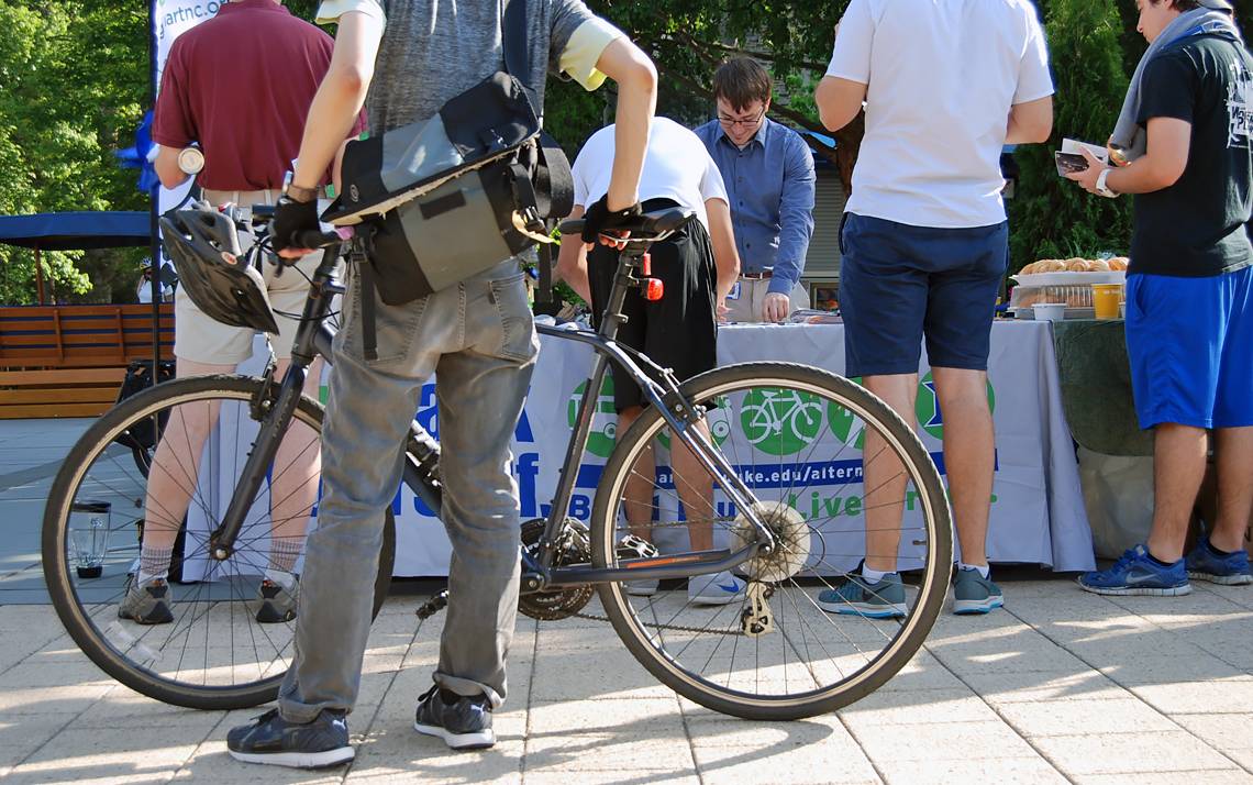 Cyclists look over free bike gear and information at Friday's Bicyclist Appreciation Breakfast at Bryan Center Plaza.