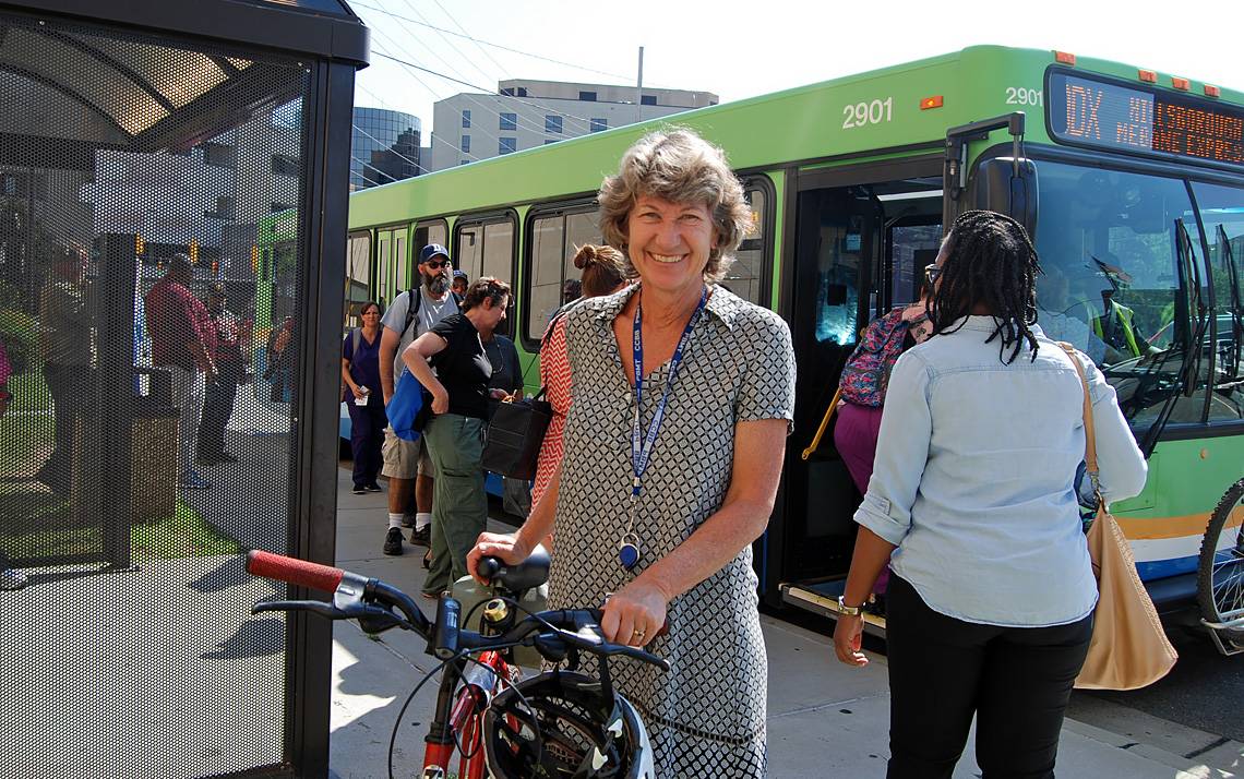 Deborah Wood with bike near a bus.