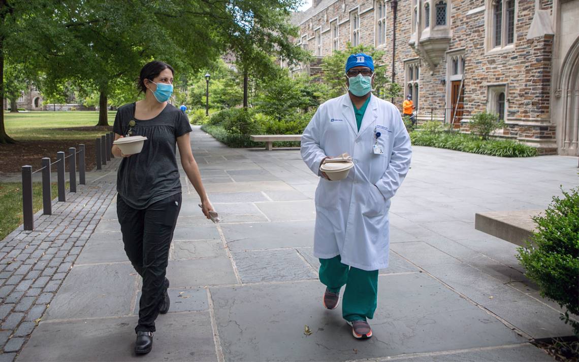 Wearing masks, trauma and critical care surgeons Amy Alger and Suresh Agarwal pick up lunch at Ginger + Soy in the Brodhead Center. Photo by Jared Lazarus, Duke University Communications.