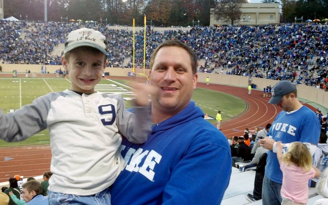 Duke employee Joe Greco and his son, Luke, enjoy a Blue Devils football game.