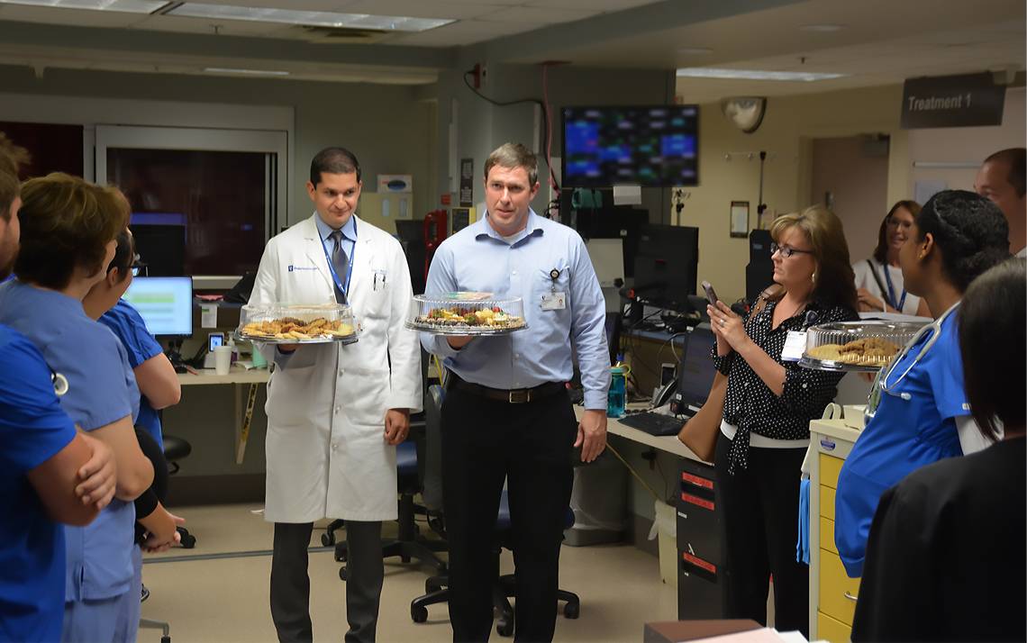 Neurosurgeons John Barr, left, and Steven Cook, right, hand out baked goods and thank you cards to employees at Duke Regional Hospital's Emergency Department. Photos by Jonathan Black.