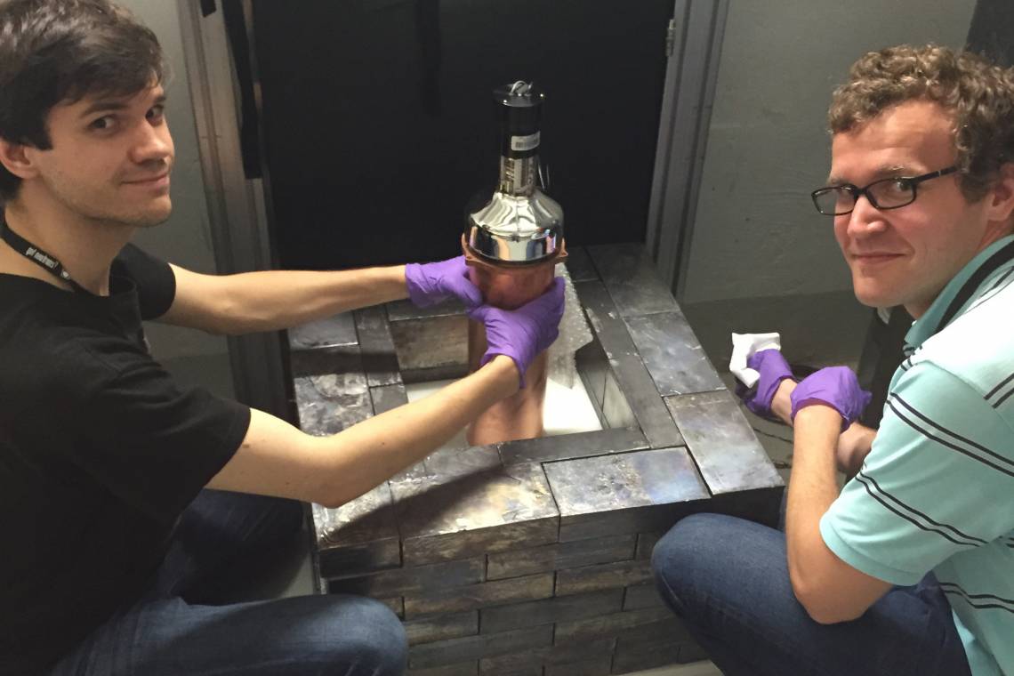 A photo of graduate students Bjorn Scholz and Grayson Rich adjusting the cesium iodide detector