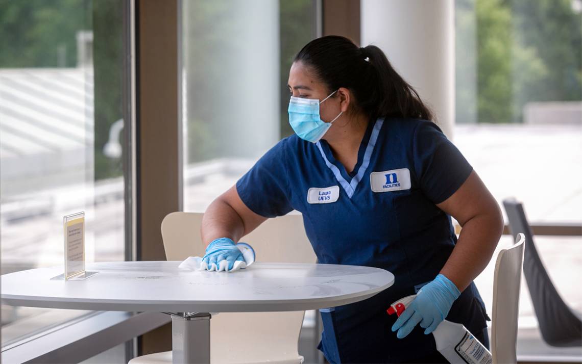 Duke Housekeeper Specialist Laura Valdovinos Robles cleans a table at the Fuqua School of Business. Photo courtesy of University Communications.