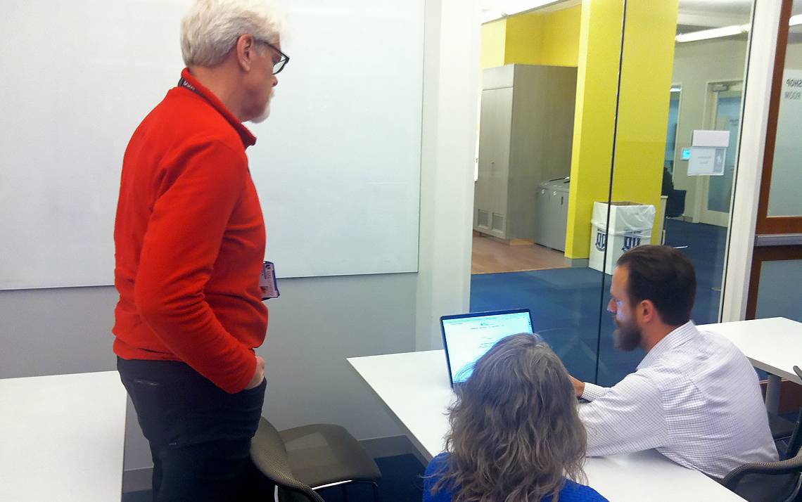 Man and woman help person with their computer.