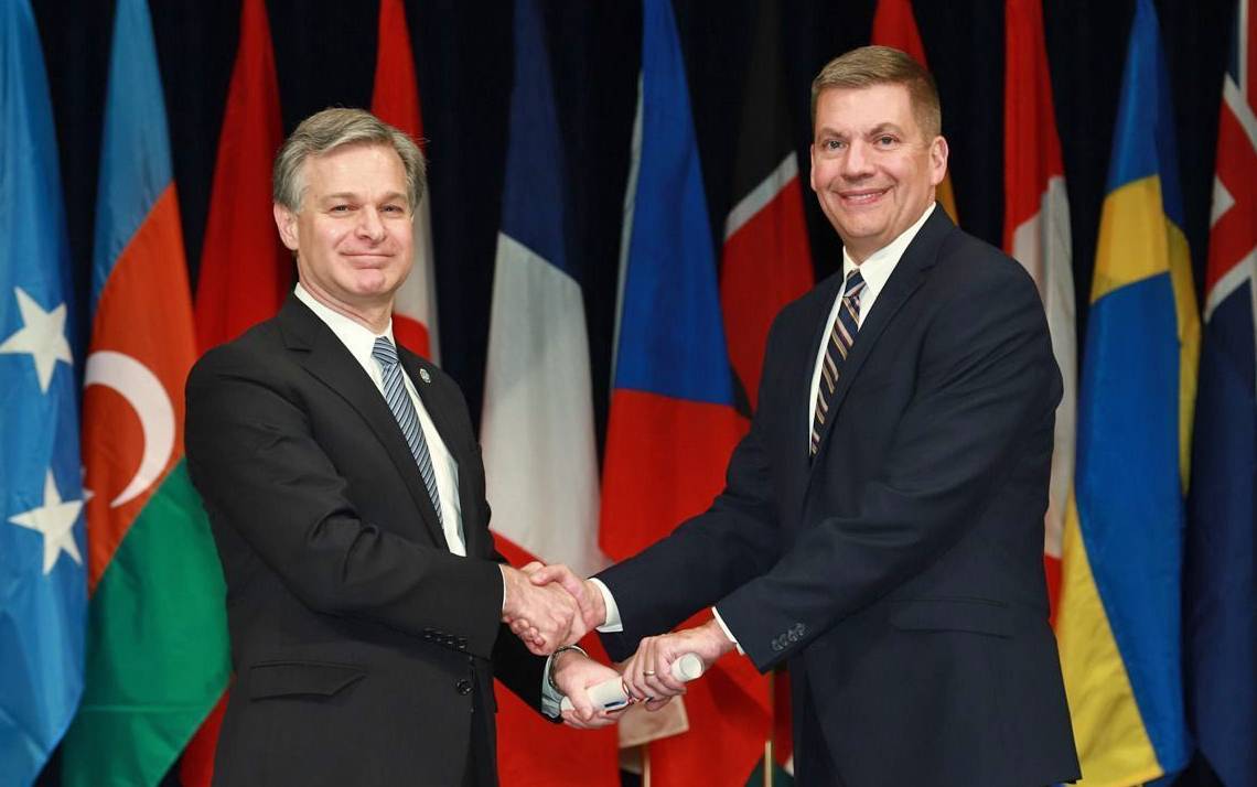 John Dailey, right, shakes hands with FBI Director Christopher Asher Wray at the National Academy graduation ceremony. Photo courtesy of John Dailey.