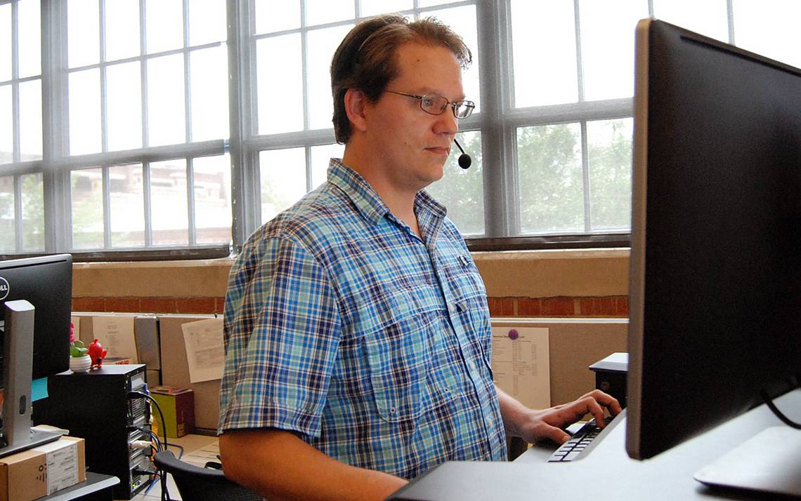 Christian Holder, an IT analyst with the OIT Service Desk, handles a call from customer. Photos by Stephen Schramm.