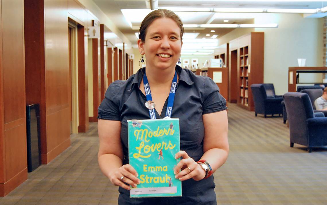 Associate Librarian Arianne Hartsell-Gundy holds one of her suggested beach reads in Perkins Library. Photo by Stephen Schramm.