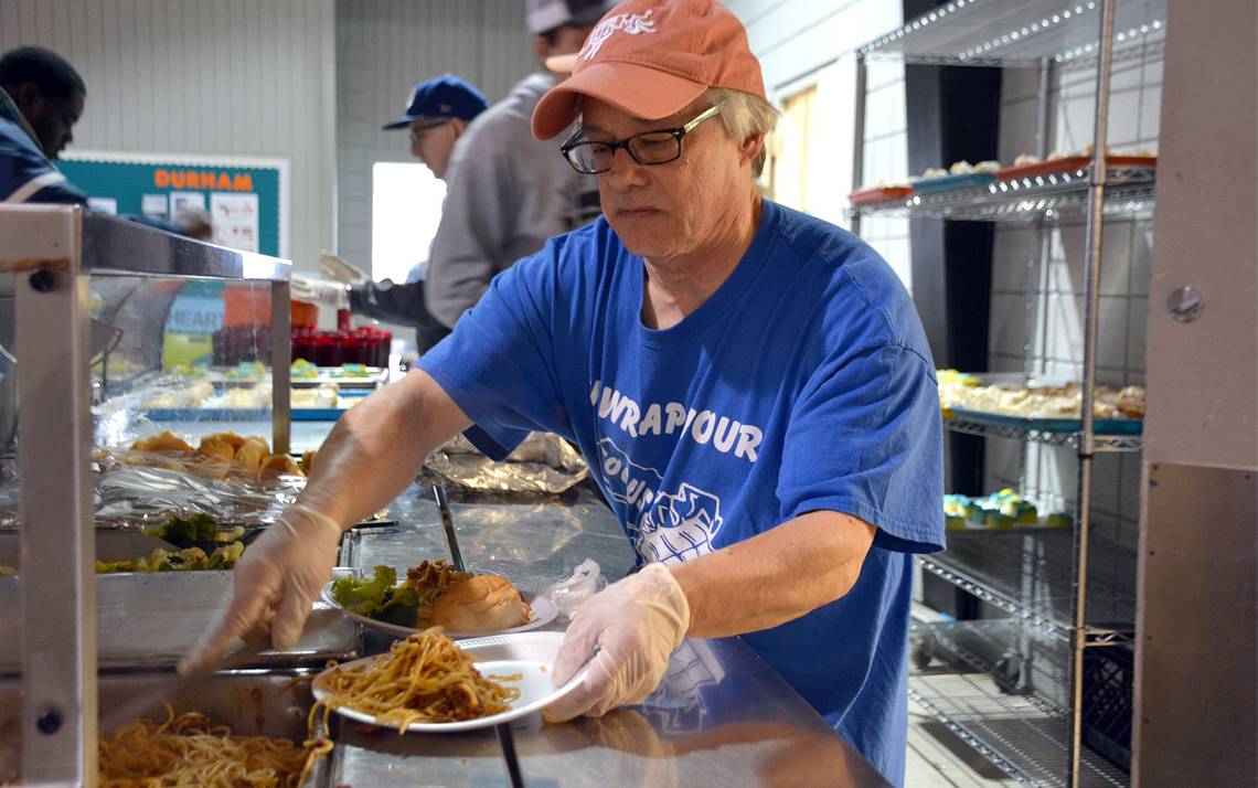Geoffrey Mock, of Duke University Communications, serves spaghetti to guests at Urban Ministries on Jan. 13. Photo by Jonathan Black.