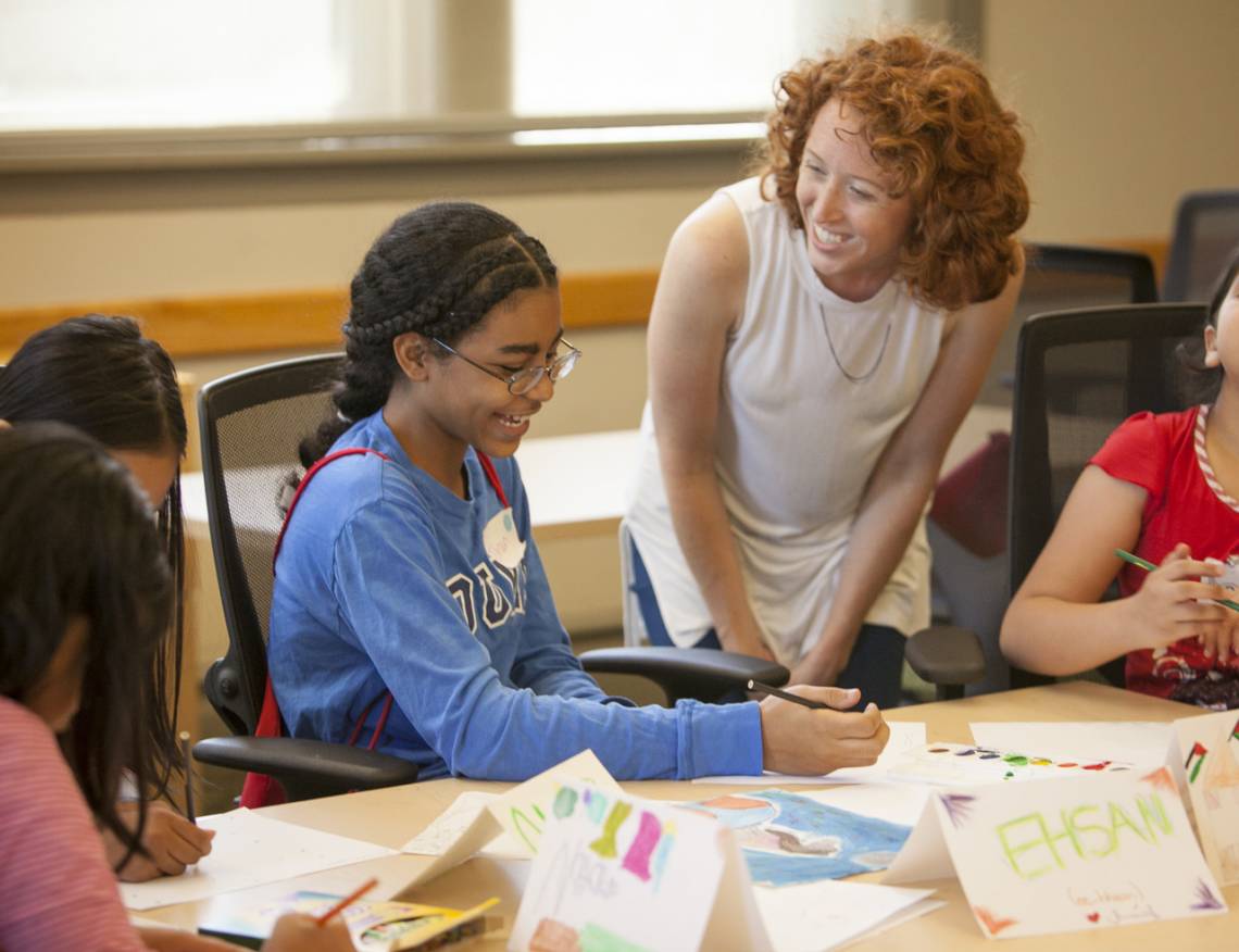 Graduate intern Samantha Boyce assists a student from Sudan with her art project. Photo by Jared Lazarus