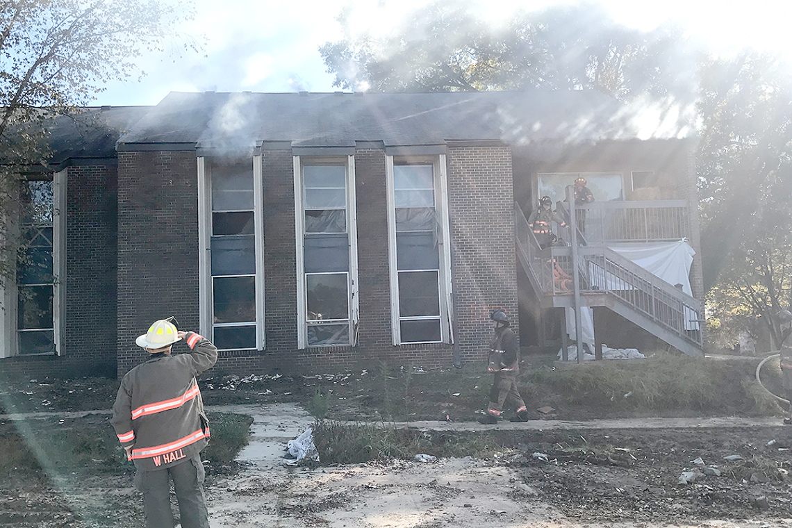 Durham firefighters enter a burning Central Campus apartment during training exercises. Photo by Hector