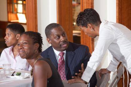 Keynote speaker Thomas LaVeist, middle, talks with panel moderator Rhonda Sharpe at a conference on health disparities.  Photo by Les Todd.