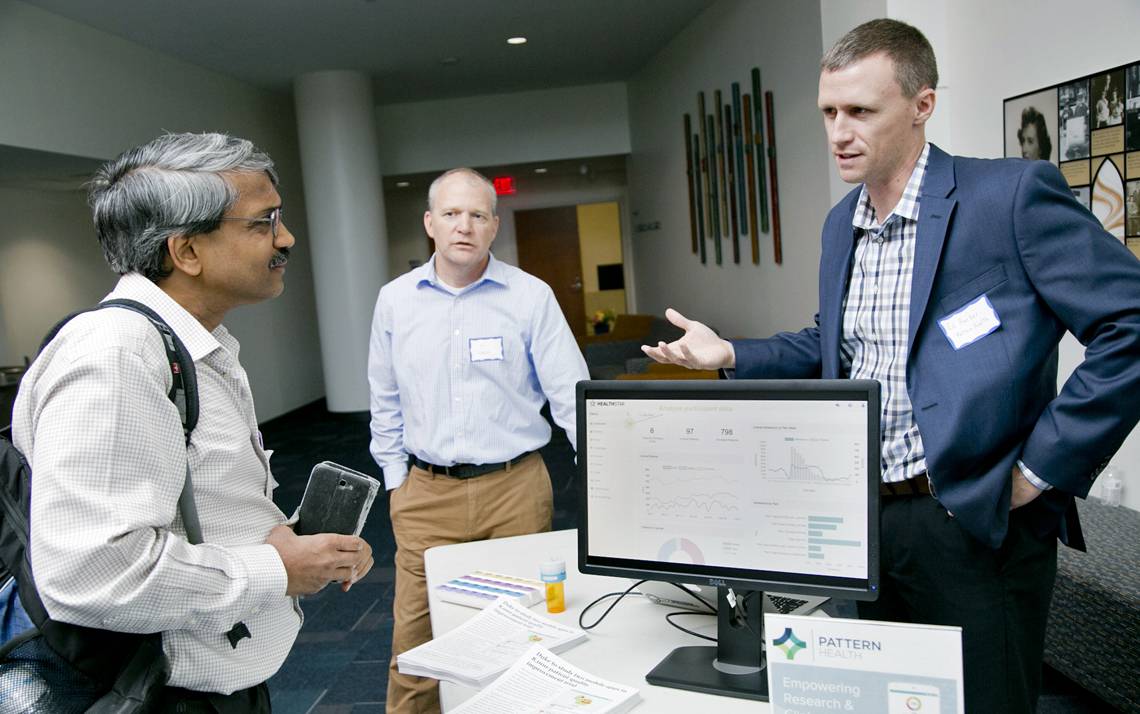 Pankaj Agarwal, far left, a database analyst in Duke Surgical Sciences, speaks with Tim Horan, center, and Ed Barber of Pattern Health, during the Mobile App Gateway kickoff at Duke.