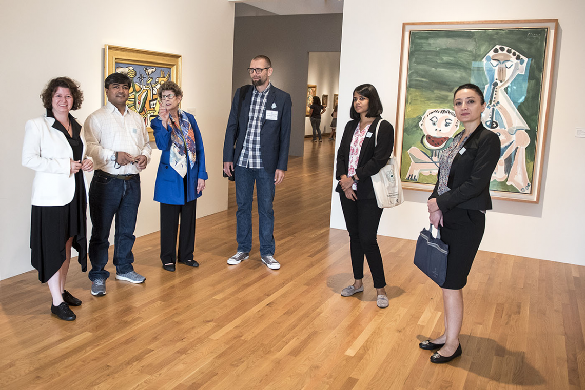 Nasher Museum Director Sarah Schroth leads five visiting cultural preservation experts into the entrance of Wilson Pavilion, pausing in front of paintings by Fernand Léger, Paysage a l'oiseau (left) and Pablo Picasso, Joueur de Flûte et Mangeur de Pastèqu