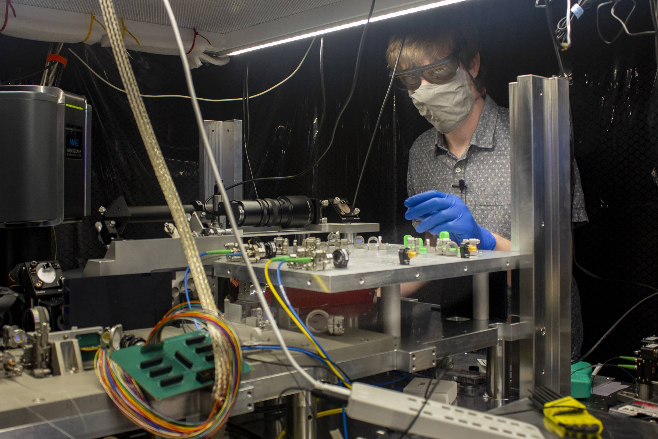 Postdoc Stephen Crain of the Jungsang Kim lab looks at quantum computing equipment in the Chesterfield Building.