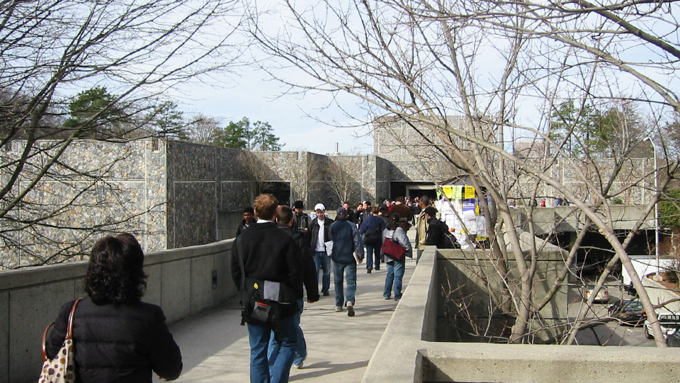 People crossing the old concrete walkway to the Bryan Center