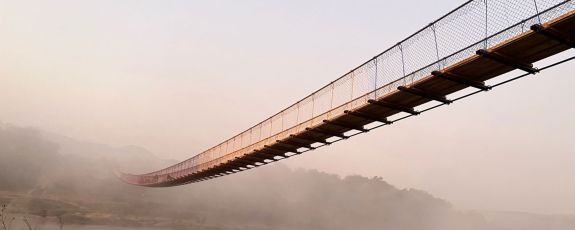 bridge built by Duke students working with community members crossing ravine in 