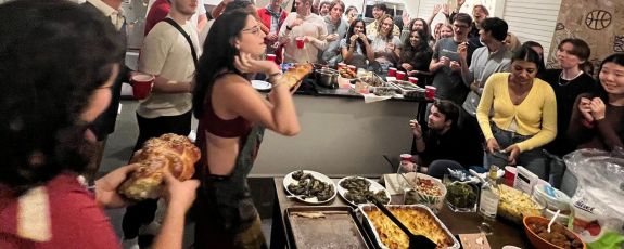 students tossing challah at a Shabbat meal at the Center for Jewish Life.