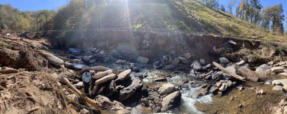 a big riverbed with rocks and a couple of children