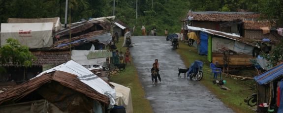 Makeshift huts made in Indonesia, with children playing in the road.