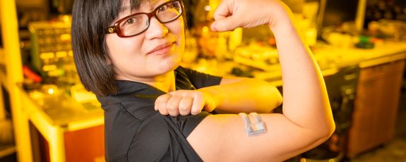 Researcher with flexible material on arm flexing muscle