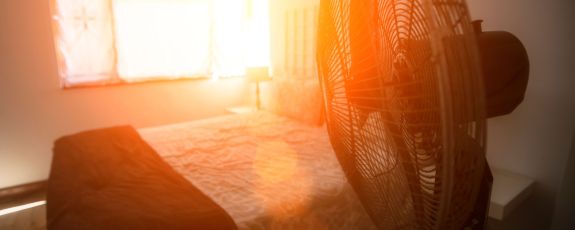 image of bedroom during severe heat, fan blowing