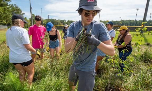 During one of orientation week's new orientation experiences, first-year students spent a morning at Durham’s Southern High School mulching tree beds and creating protection for new tree plantings. (Bill Snead/University Communications)