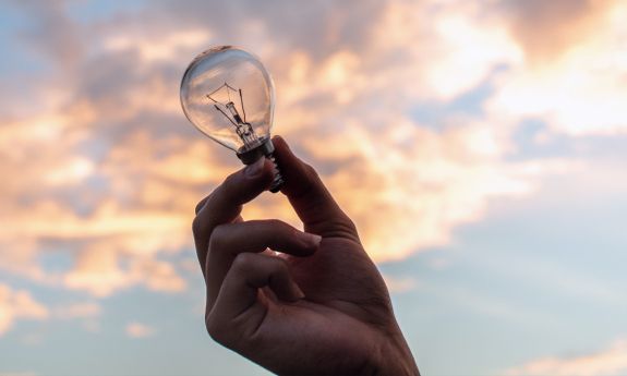 A hand holding a lightbulb.