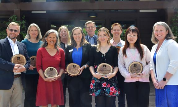 A group of people posing with awards