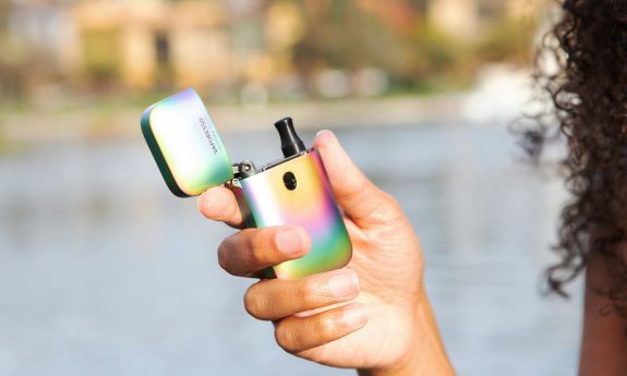 A vaping pen is shown held by a hand.
