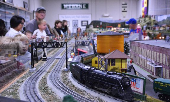 People watch a model train.