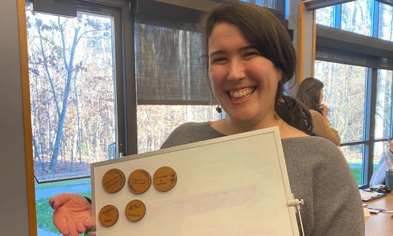 Sarah Barton holds up a board with magnets on it.