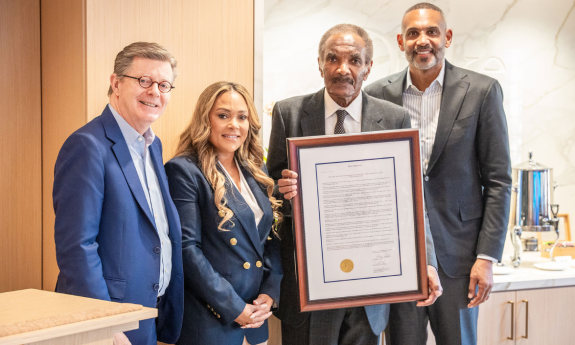 President Vincent Price presents the trustee resolution to Tamia Hill, Calvin Hill and Grant Hill during the Friday ceremony.