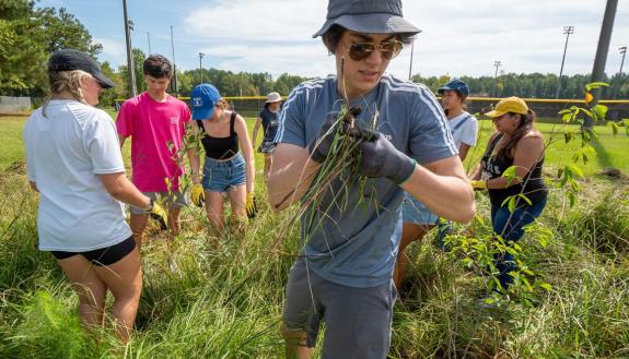 During one of orientation week's new orientation experiences, first-year students spent a morning at Durham’s Southern High School mulching tree beds and creating protection for new tree plantings. (Bill Snead/University Communications)