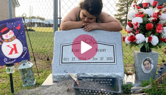 Native American girl leaning on tombstone