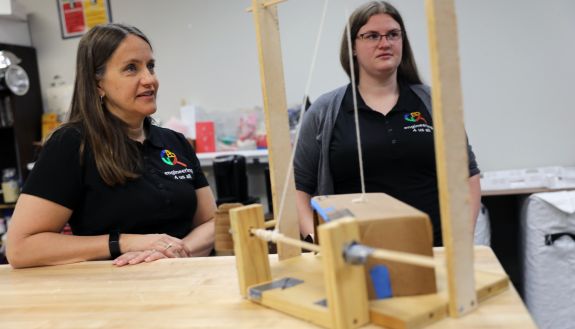 Stacy Klein-Gardner (left) and Emily Moreno-Hernandez (right) learn more about one of the student teams' lemur feeder designs