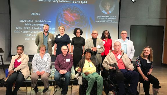 A group of 12 people, one row seated, another standing behind, pose for a photo.