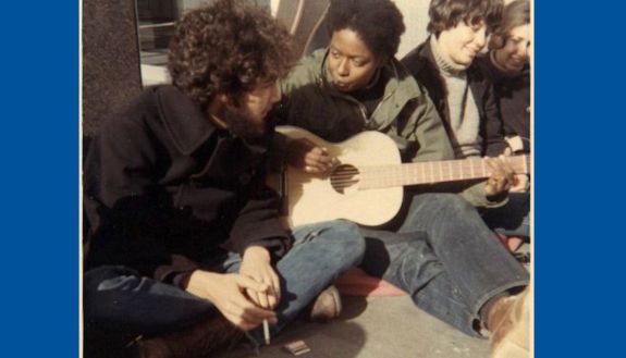 Old photo of Mandy Carter playing the guitar with small group