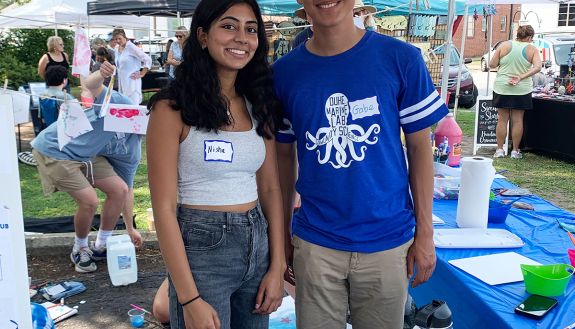 Nisha Jakkinpala and Gabe Mendoza greet visitors at the Beaufort Farmer’s Market. The students led an outreach event to help promote clean storm drains.