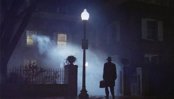 Nighttime photo with man standing by streetlamp 